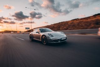 Silver sport cabriolet driving across hills