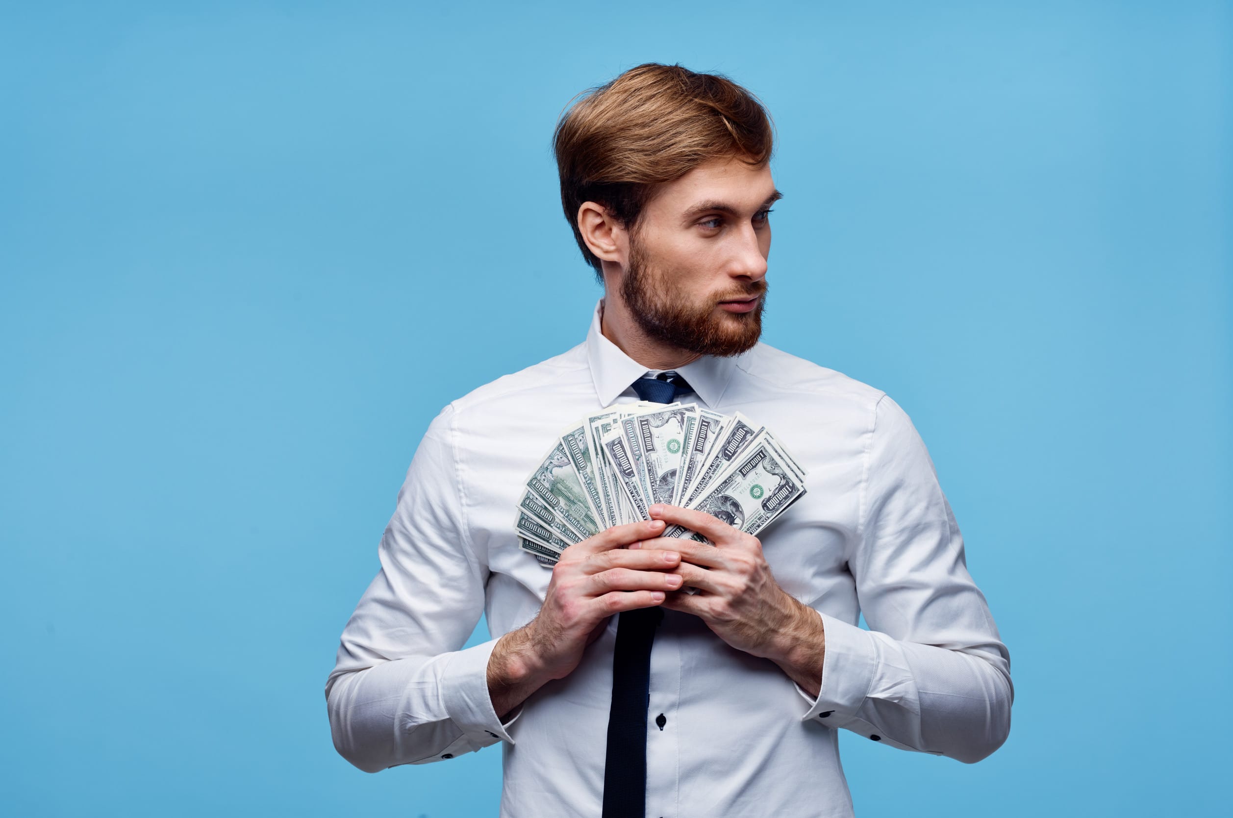 A millionaire holding money that they earned in a hidden income stream