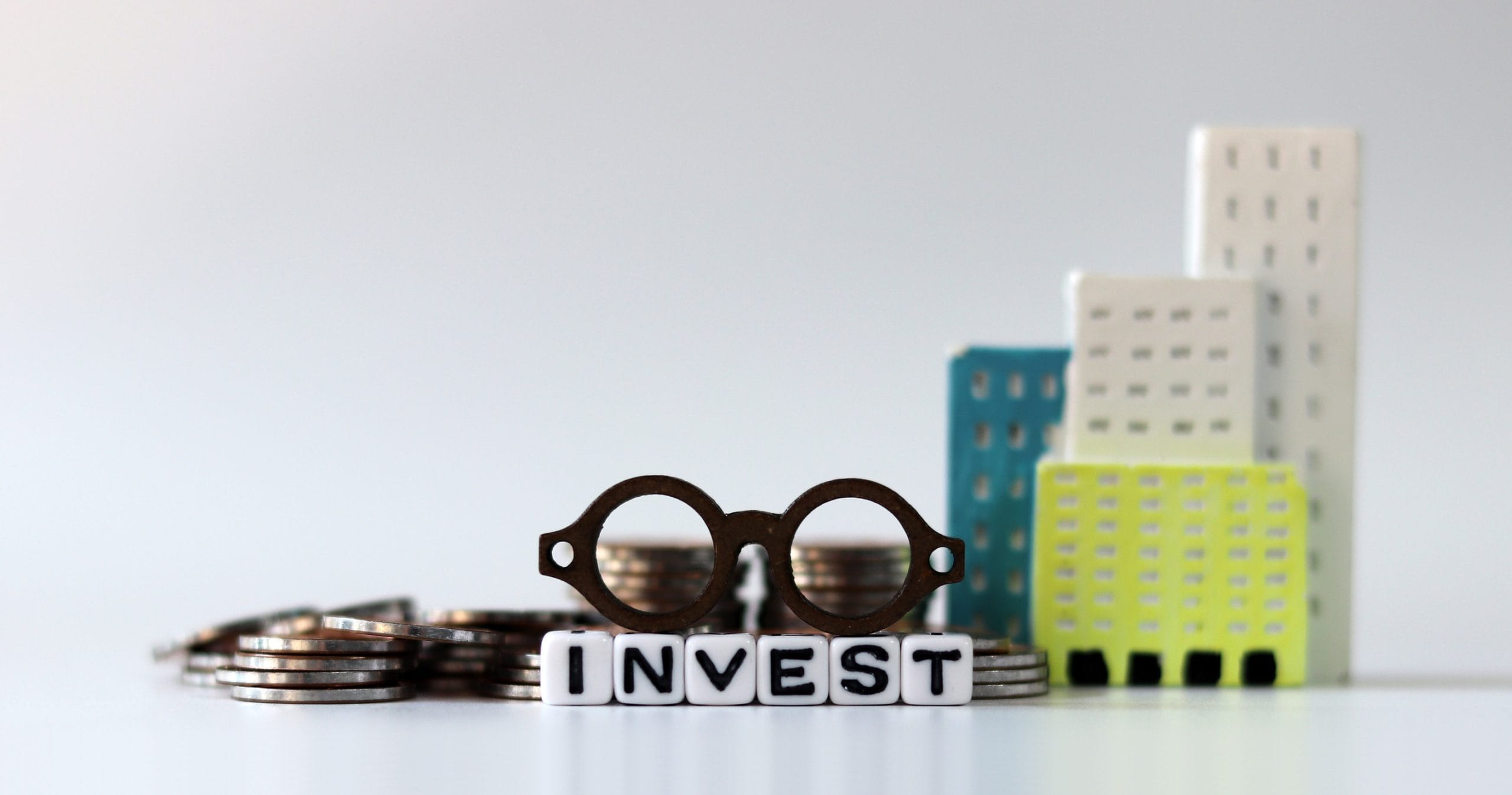 A collection of items symbolizing someone investing, which is a way to build wealth without even trying