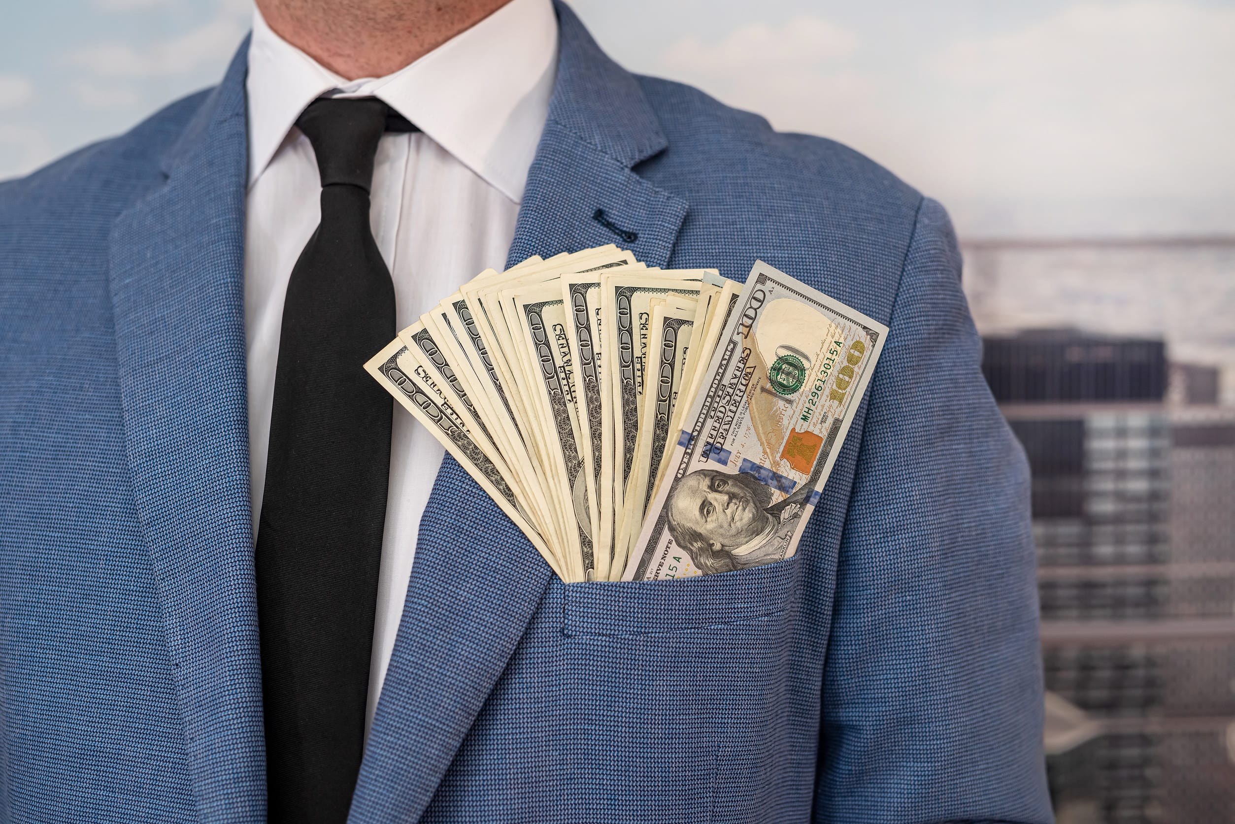 A man with cash in his jacket pocket, symbolzing his wealth