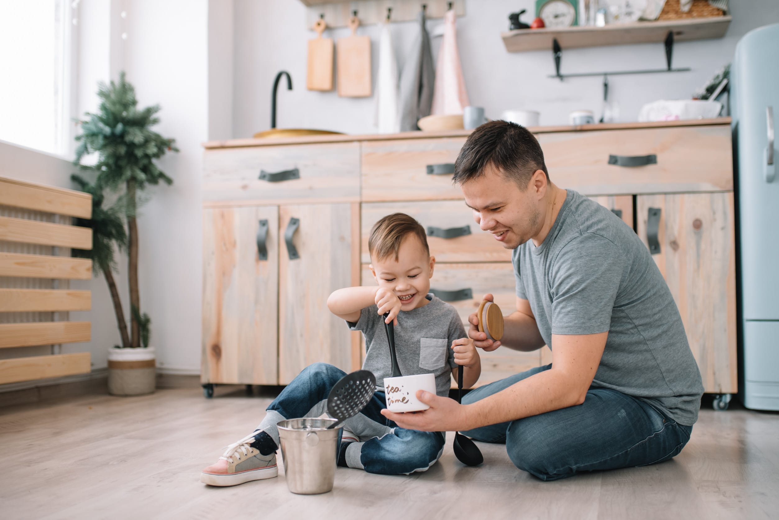 father playing with son in the kitchen