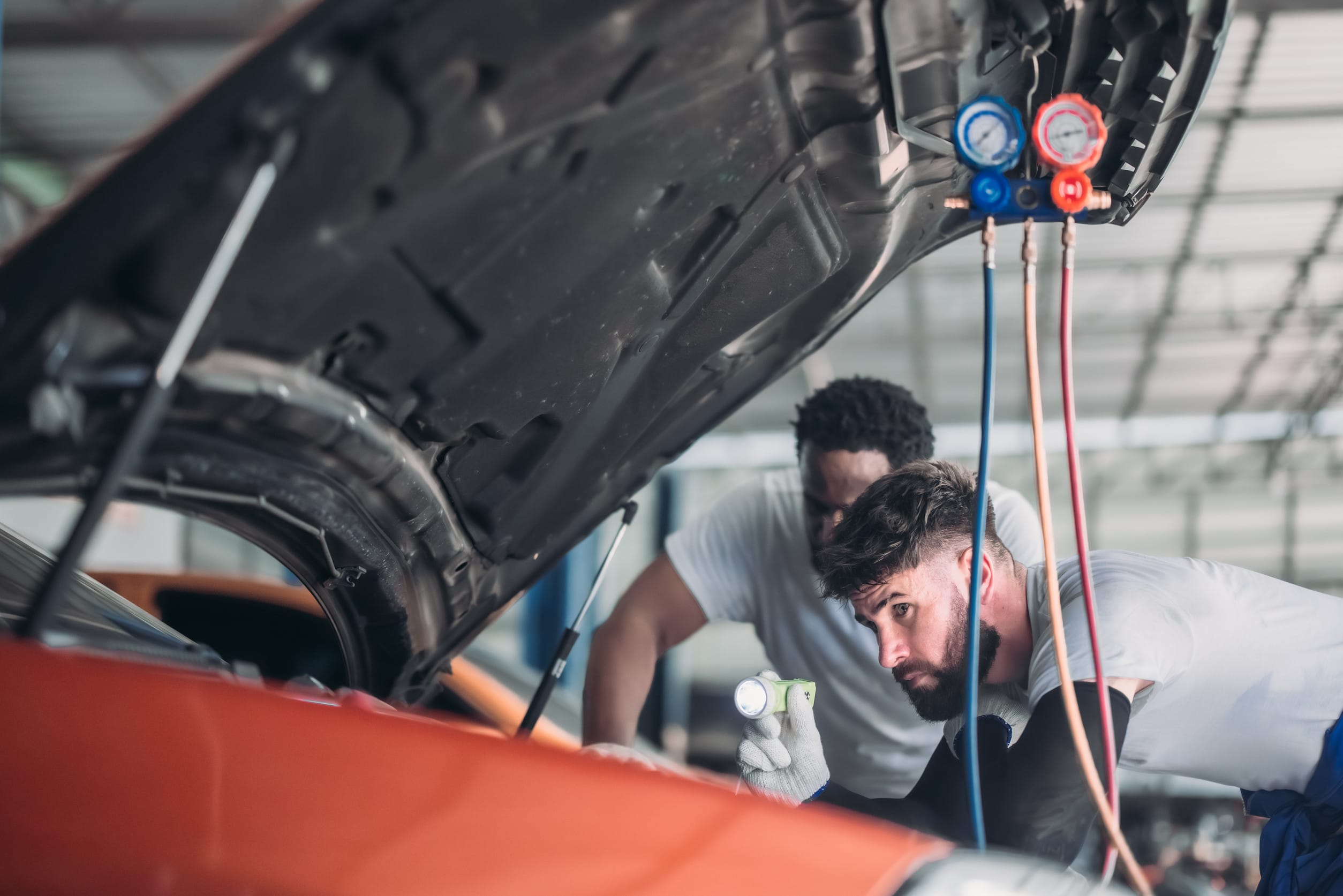 Car mehanic looking under the hood
