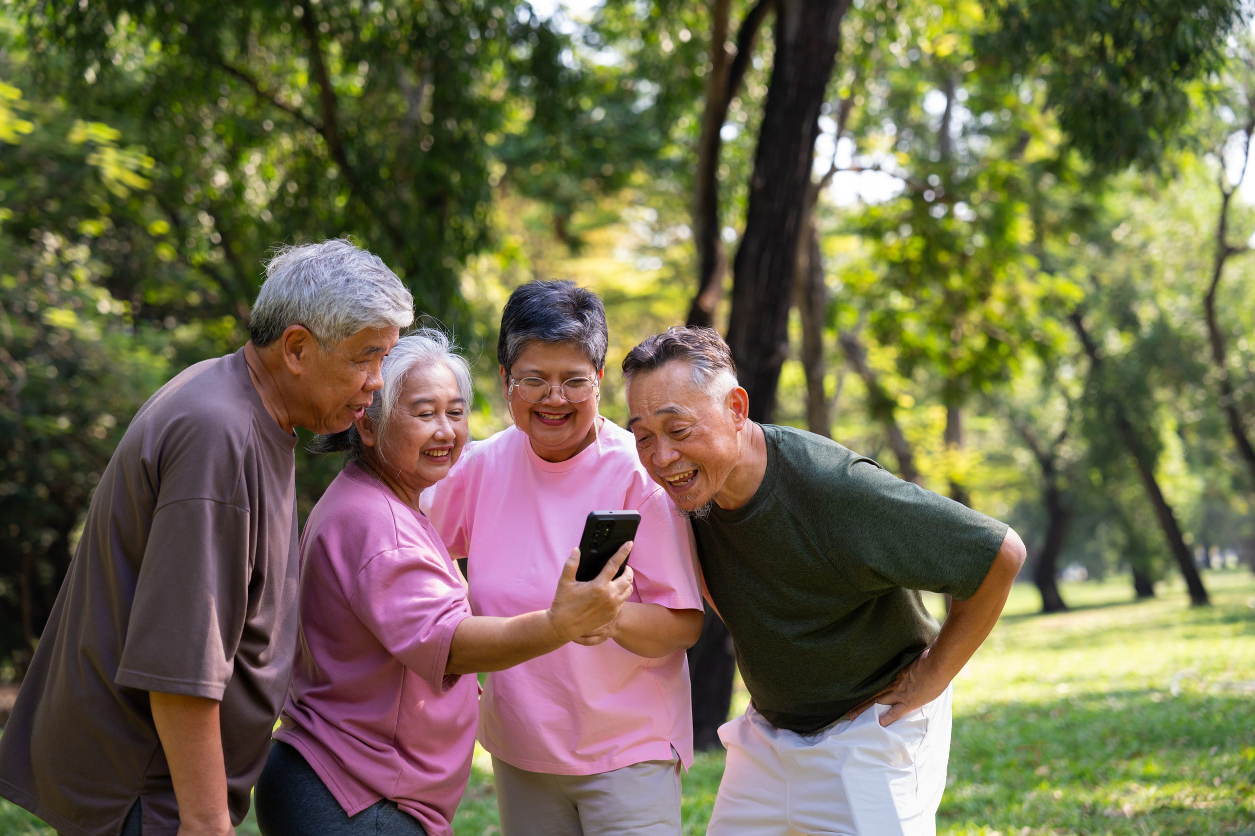 A group of senior citizens using a cell phone, possibly with a discount
