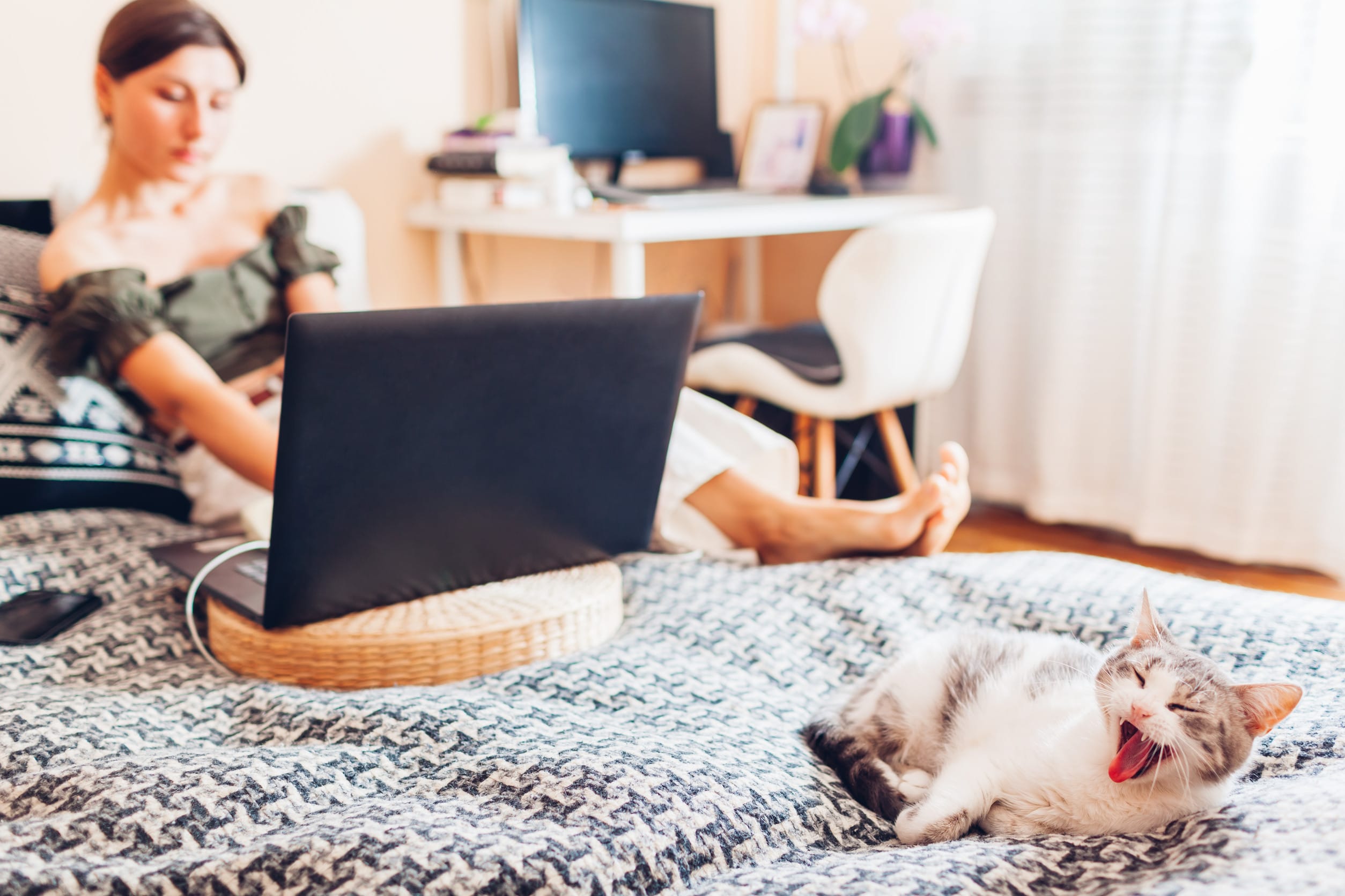 A woman on her laptop in bed as she gets to work from home
