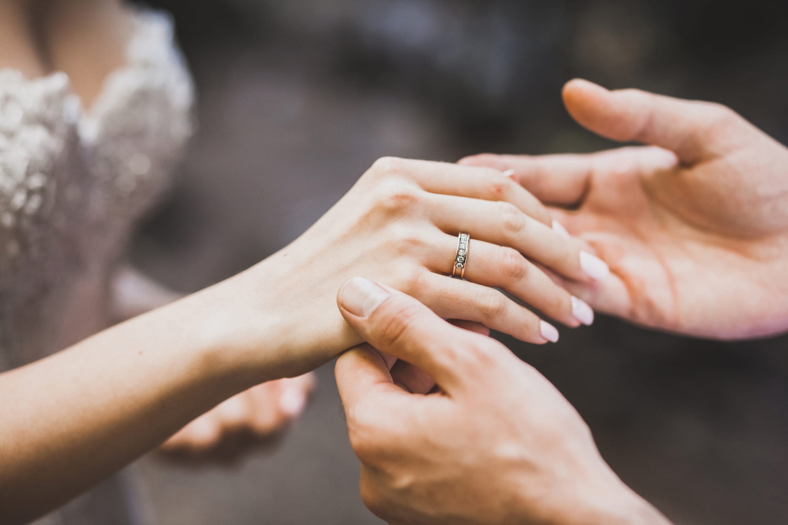 Man holding a woman's hand with a ring on her finger